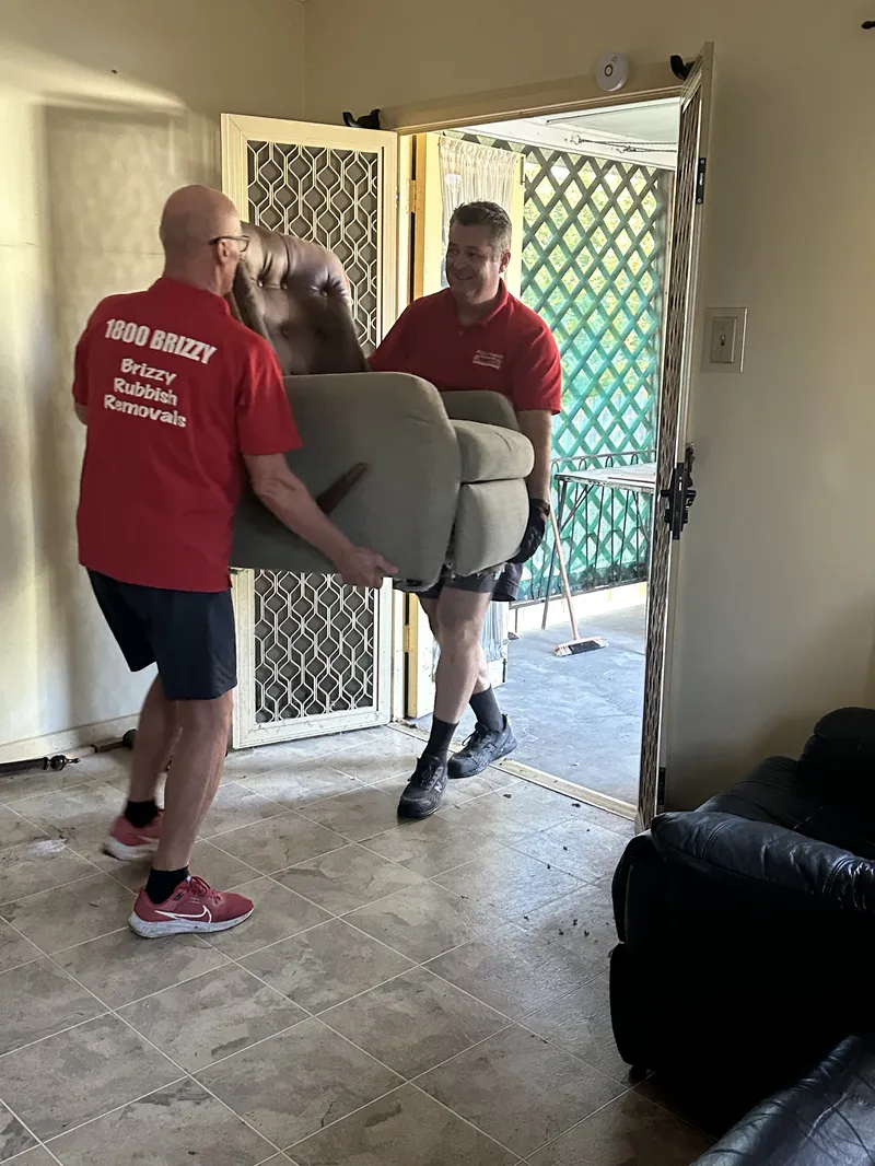 Brizzy Rubbish Removals team carrying a recliner chair in Everton Park