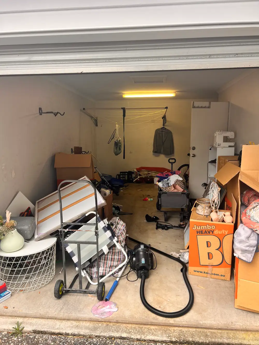 Cluttered garage at a Hawthorne unit before rubbish removal
