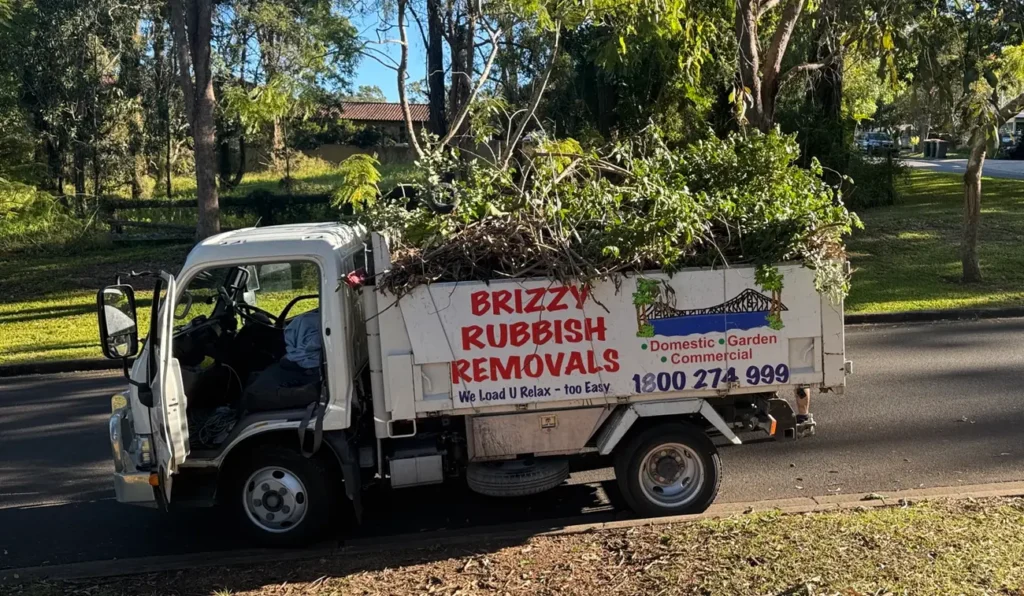 Brizzy Rubbish Removals truck loaded above the sides with branches and garden waste on a Brisbane street