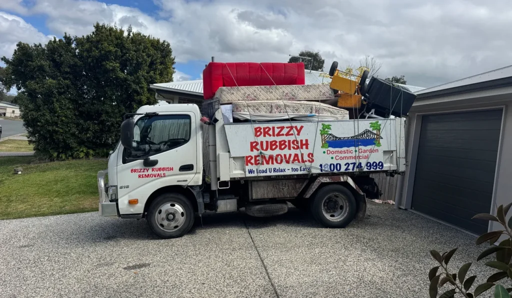 Brizzy Rubbish Removals truck loaded with a couch, mattresses and household items from a house clean out in Brisbane