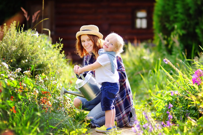 Gardener with toddler removing garden waste and weeds